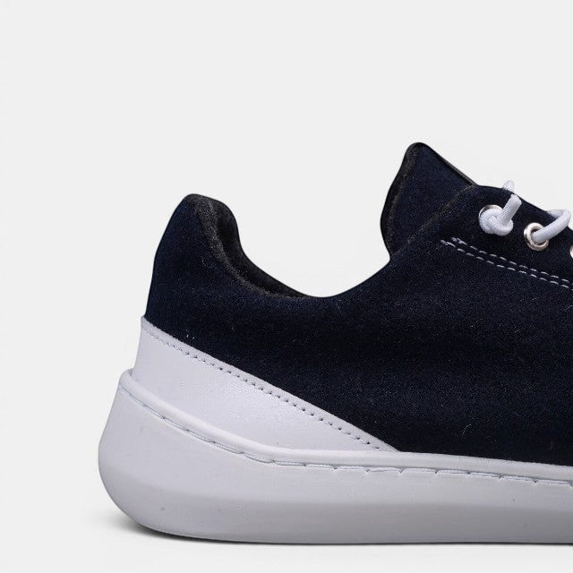 Baabuk navy blue wool low-top barefoot sneakers with white laces and white leather accents.